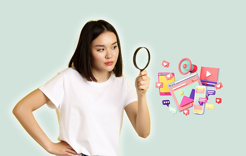 Desinformation und Fake News erkennen Ein Mädchen mit schwarzen, schulterlangen Haaren hat den rechten Arm in die Hüfte gestützt und hält im linken Arm eine Lupe, mit der sie auf grafische Darstellungen von Handy, Tablet, Internetbrowser, Videoportal, Kurznachrichten und Megafon schaut.