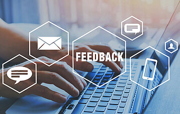 Verschiedene Feedback-Icons vor Computer-Tastatur