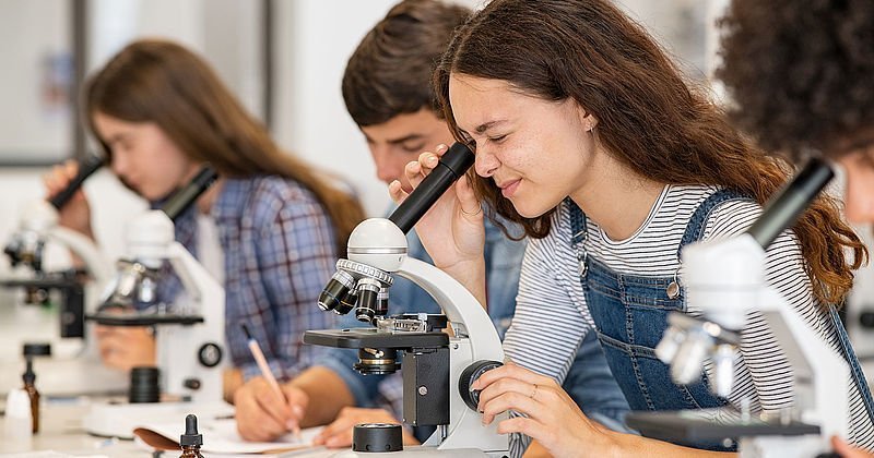 Gruppe von Studenten im Wissenschaftslabor am Mikroskop