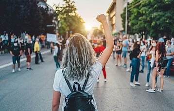 Mädchen von hinten hebt den rechten Arm
