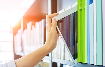 Laptop wird aus einem Bücherregal gezogen