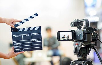 Filmklappe und Kamera beim Filmdreh