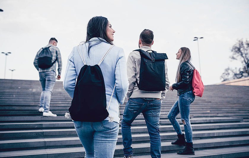 Jugendliche gehen eine Treppe hinauf.