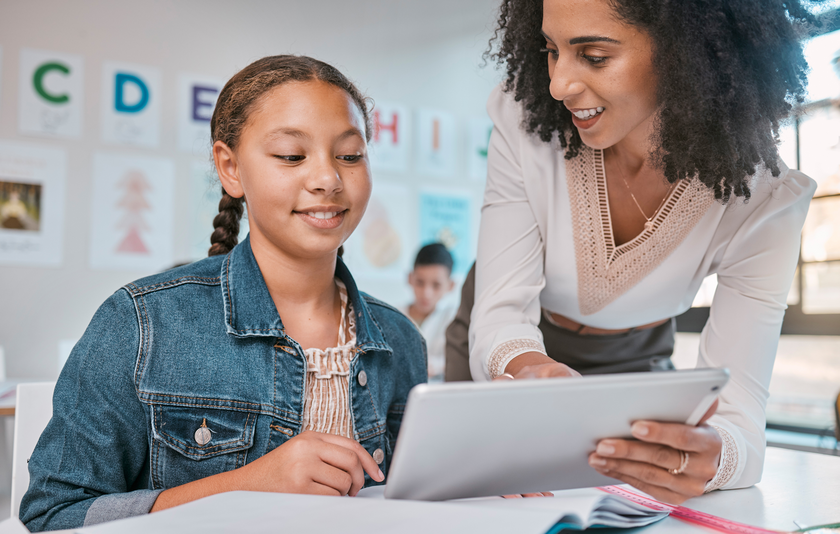 Lehrin zeigt Schülerin Tablet - kostenlose Lernportale