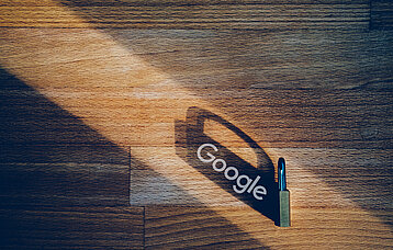 Google-Schriftzug im Schatten eines Vorhängeschlosses