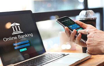 Laptop und Smartphone mit Online-Banking-Oberfläche
