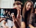 Drei Jugendliche werden mit einem Smartphone fotografiert