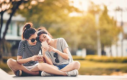 Zwei Mädchen mit Smartphones im Park