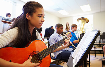 Orchester in der Schule: Teenager beim gemeinsamen Musizieren.