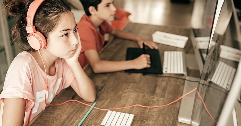 Kinder mit Kopfhörern an Computern
