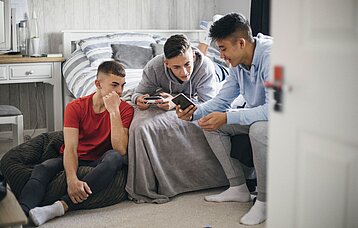 Drei Jungs schauen auf ein Smartphone