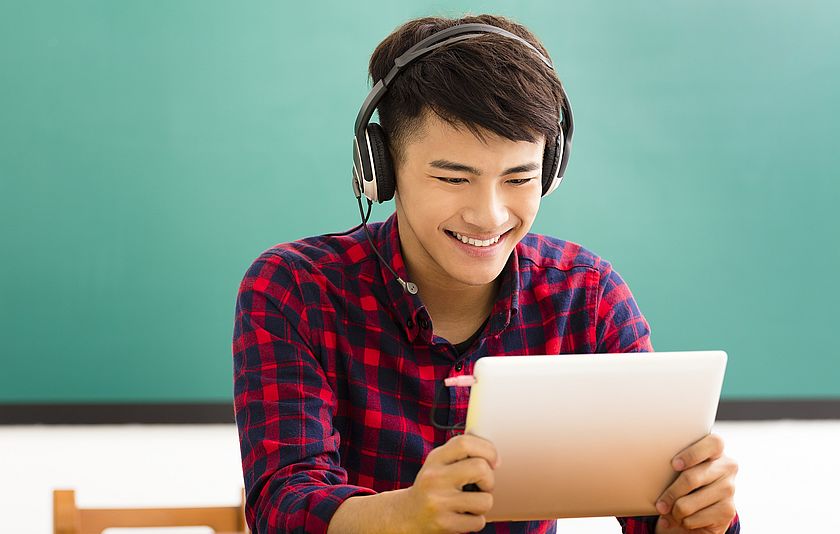 Schüler mit Kopfhörer am Tablet