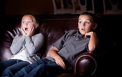 Jugendliche mit verängstigtem Blick beim Fernsehschauen.
