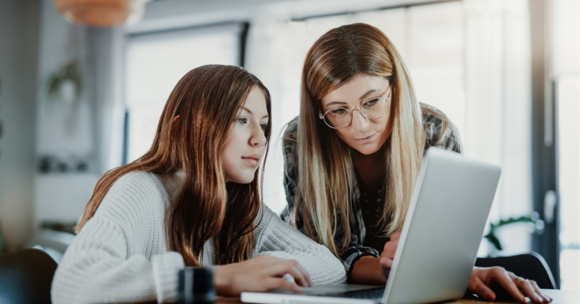 Mutter und Tochter schauen auf einen Laptop