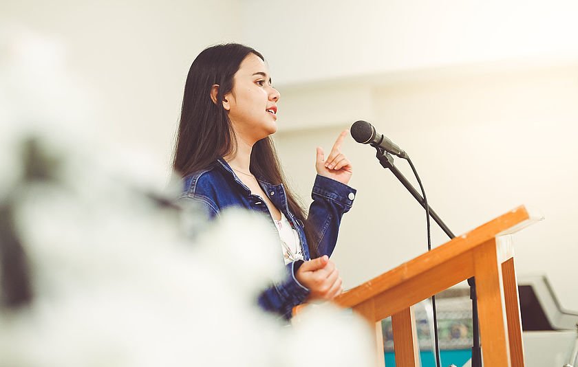 Jugendliche spricht an einem Rednerpult