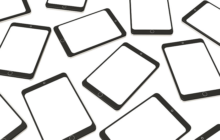 Viele Tablets liegen ungeordnet auf einem Tisch.