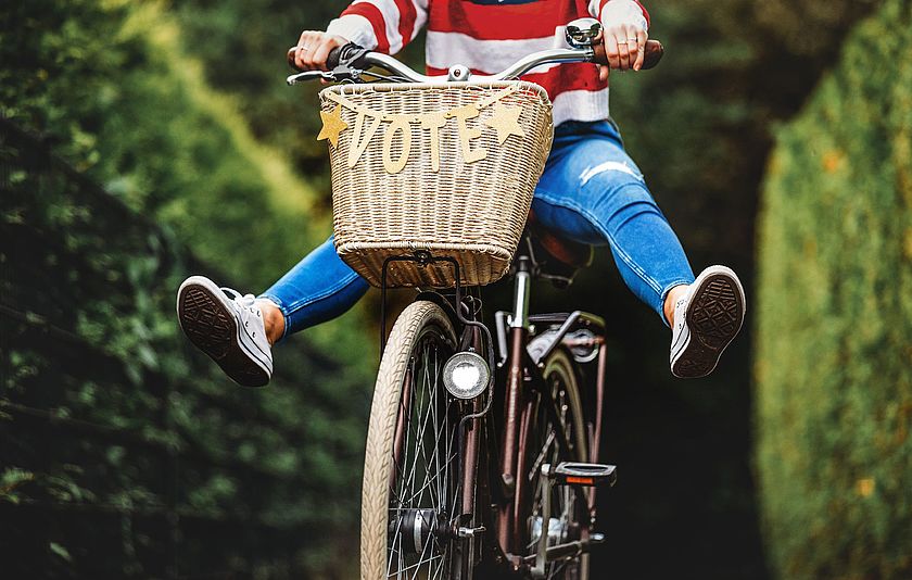 Eine Person sitzt auf einem Fahrrad mit der Aufschrift Vote