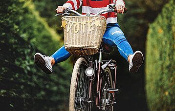 Eine Person sitzt auf einem Fahrrad mit der Aufschrift Vote
