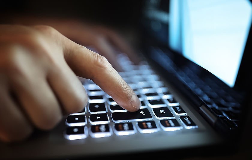 Hände auf beleuchteter Laptop-Tastatur