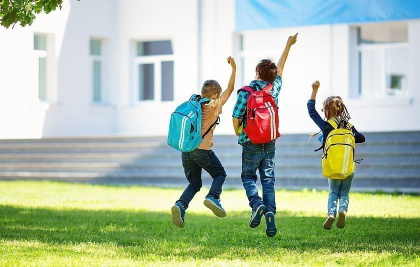 Hüpfende Kinder auf Rasenfläche