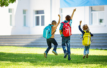 Hüpfende Kinder auf Rasenfläche