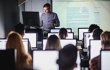 PC-Schulklasse mit Lehrer am Whiteboard
