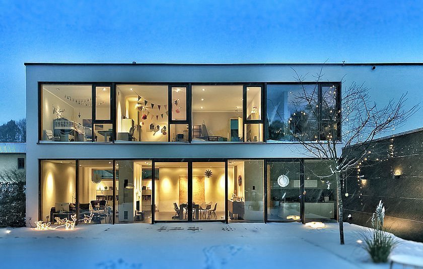 Hausfassade bei Nacht mit eingeschalteten Lichtern im Inneren