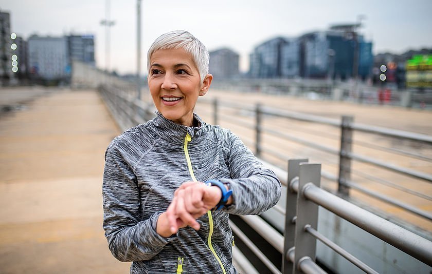 Frau schaut auf ihre Fitnessuhr