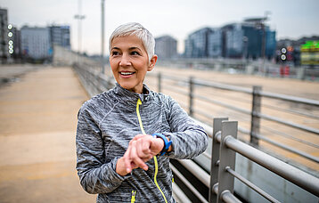 Frau schaut auf ihre Fitnessuhr
