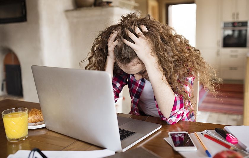 Ein Mädchen zerzaust sich die Haare vor einem Laptopop