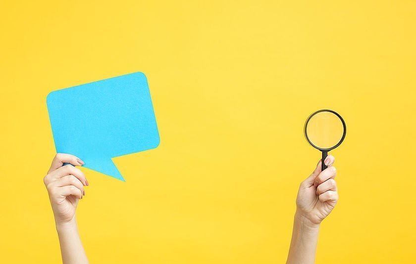 Zwei Hände halten eine Sprechblase bzw. eine Lupe in die Höhe