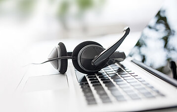 Headphone liegt auf einer Laptop-Tastatur