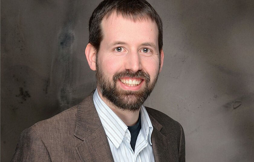 Portraitfoto von Prof. Dr. Boelmann, einem dunkelhaarigen Mann mit Bart in den 40ern