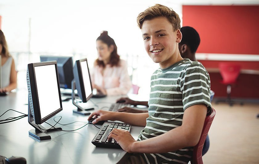 Jungendlicher am PC im Klassenzimmer Jungendlicher am PC im Klassenzimmer