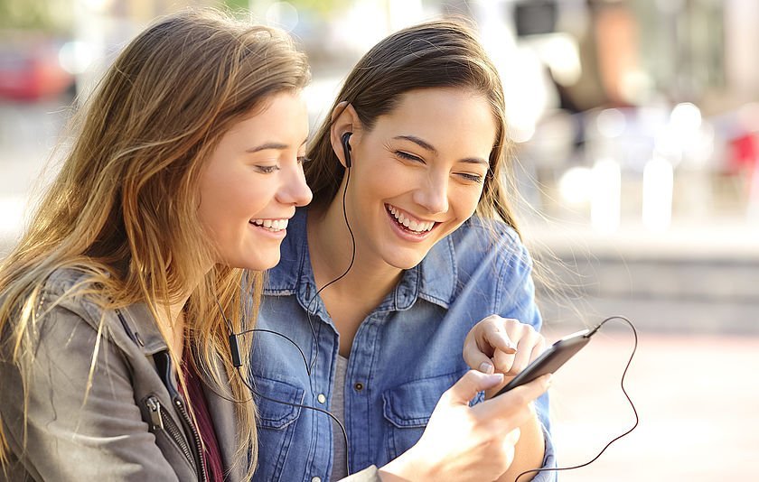 Zwei Mädchen sehen auf ein Smartphone