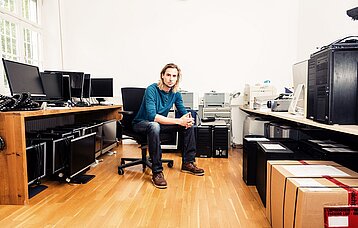 Junger Mann in einem Raum mit technischen Geräten