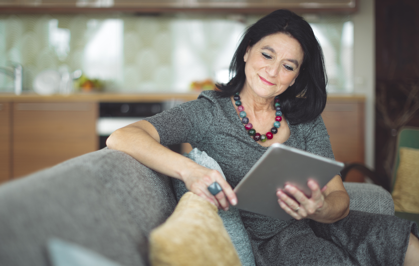 Lehrerin mit Tablet auf dem Sofa