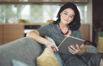 Lehrerin mit Tablet auf dem Sofa