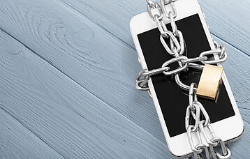 Smartphone mit Kette und Schloss gesichert