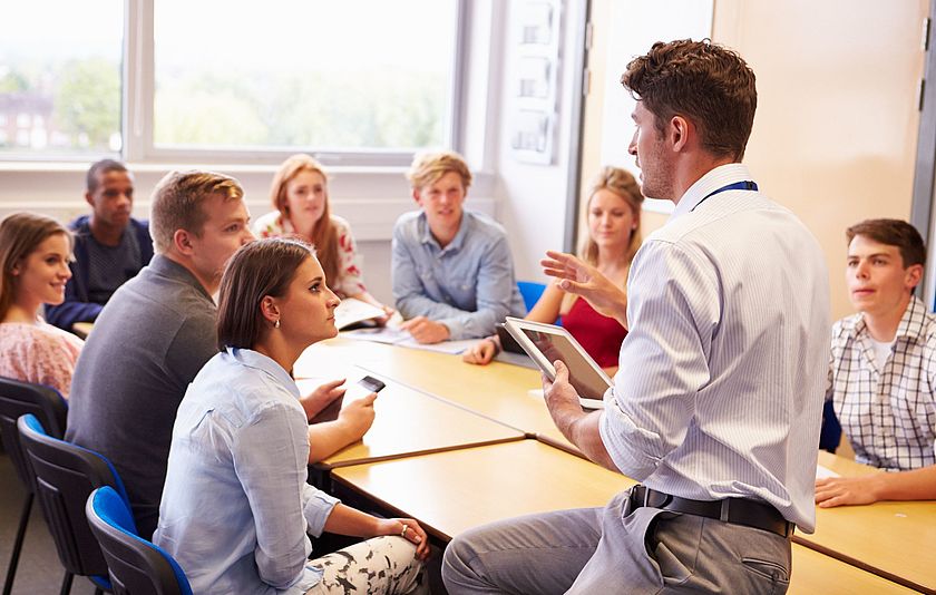 Ein Lehrer im Klassenzimmer mit Schülerinnen und Schülern.