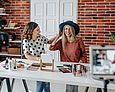 Zwei Frauen sitzen vor einer Kamera und machen Werbung für Beauty-Produkte  