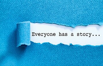 Weggerissener Papierstreifen, unter dem der Schriftzug Everyone has a story.. erscheint