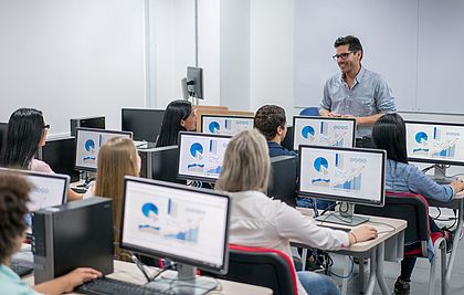 Klassenzimmer mit Schülerinnen und Schülern an Bildschirmen