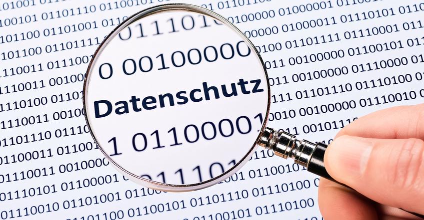 Das Wort Datenschutz mit einer Lupe vergrößert