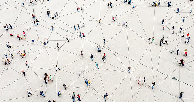 Viele Menschen von oben auf einem Platz, die ein Soziales Netzwerk symbolisieren.