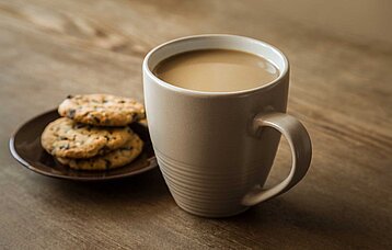Kaffeetasse und Kekse auf einem Holztisch