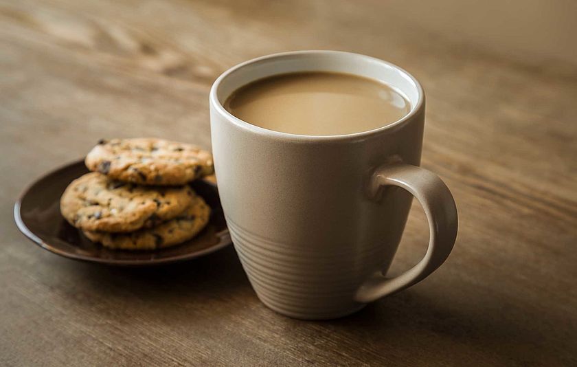 Kaffeetasse und Kekse auf einem Holztisch