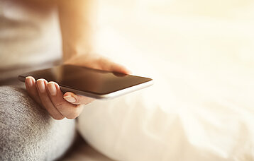 Weibliche Hand hält ein Smartphone